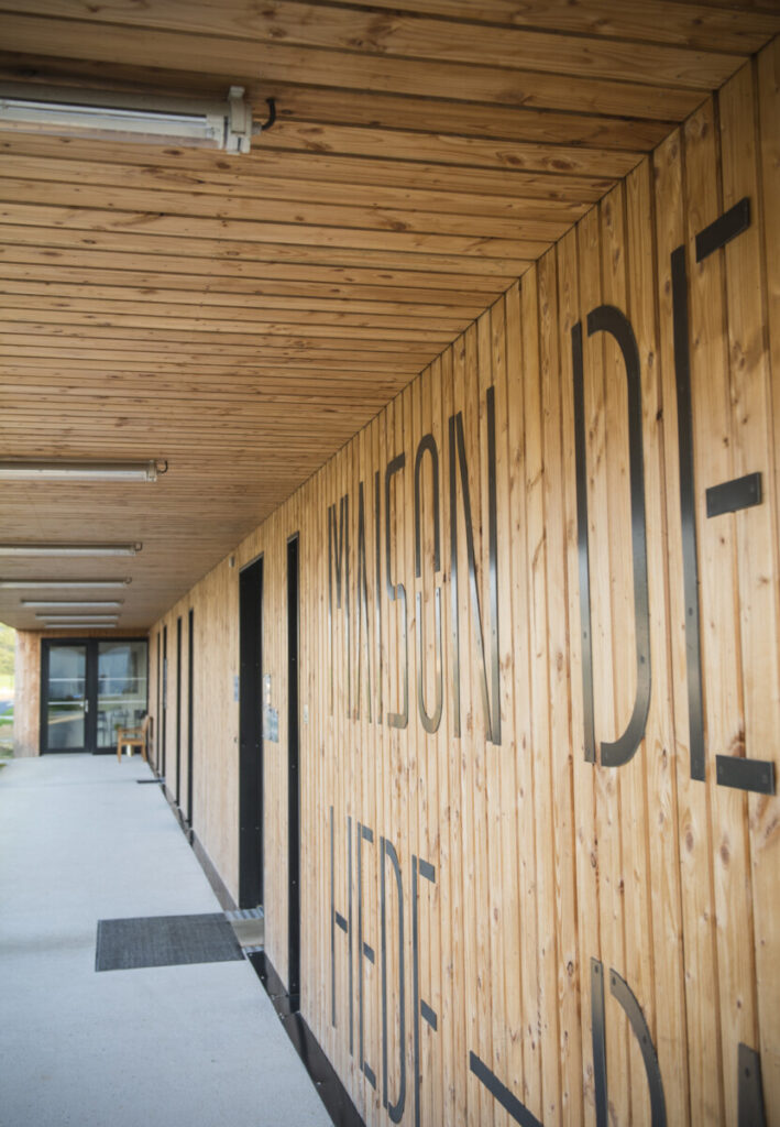 Le bardage bois du mur se poursuit au plafond créant un lien entre horizontal et vertical.